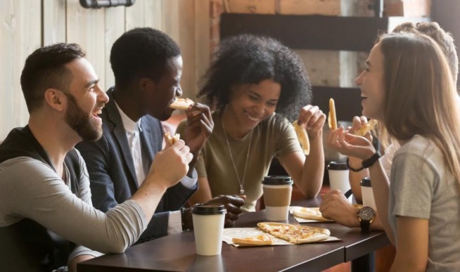a group of people eating pizza