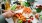 person cutting a kitchen counter full of vegetables